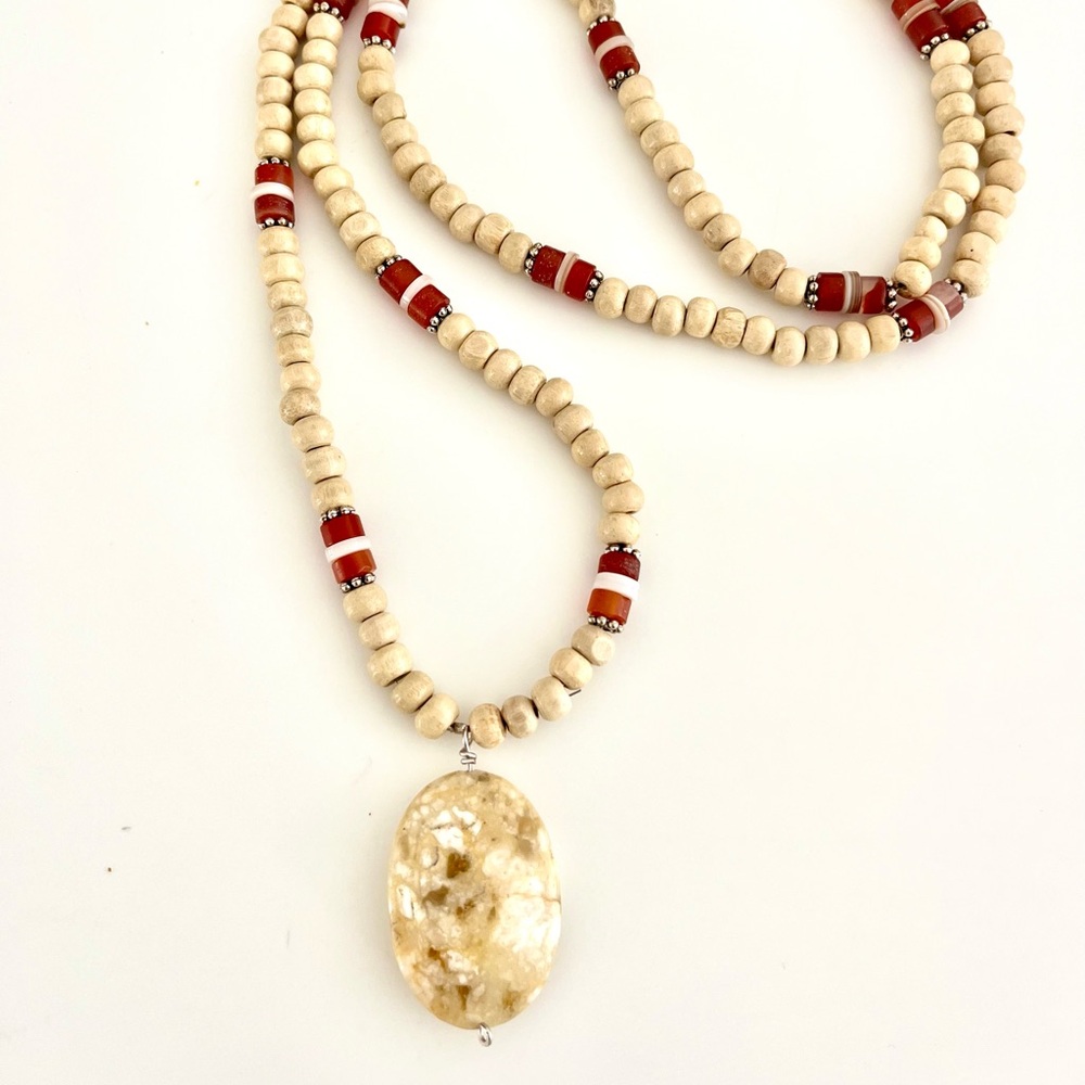 Boho wooden beaded necklace with bone and carnelian details and beige charm.